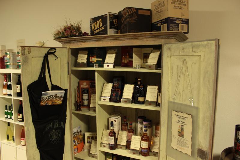 Geöffneter Präsentationsschrank mit Whisky Spezialitäten im Verkaufsraum