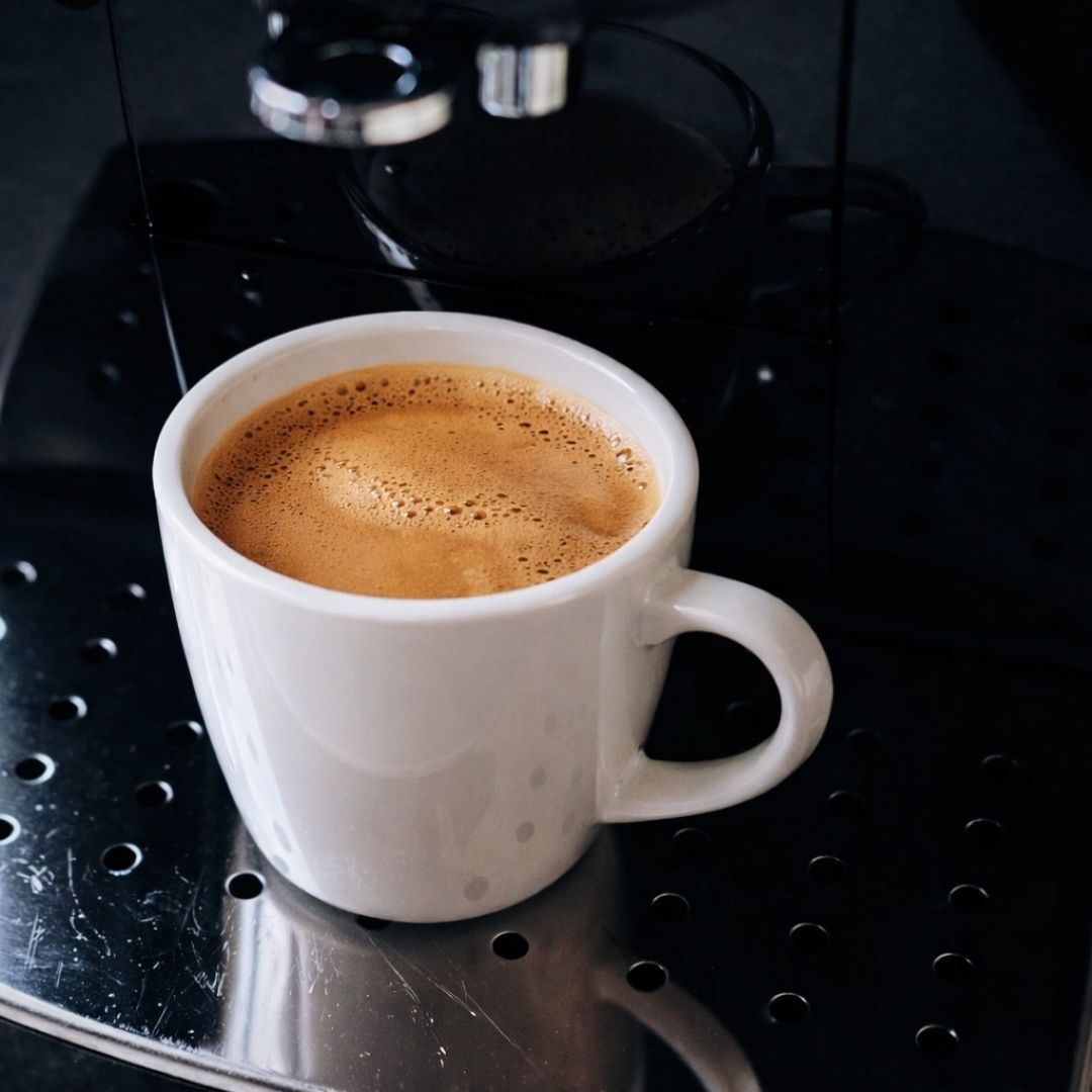 Frisch gebrühter Espresso in weißer Tasse (Kaffeemaschine)